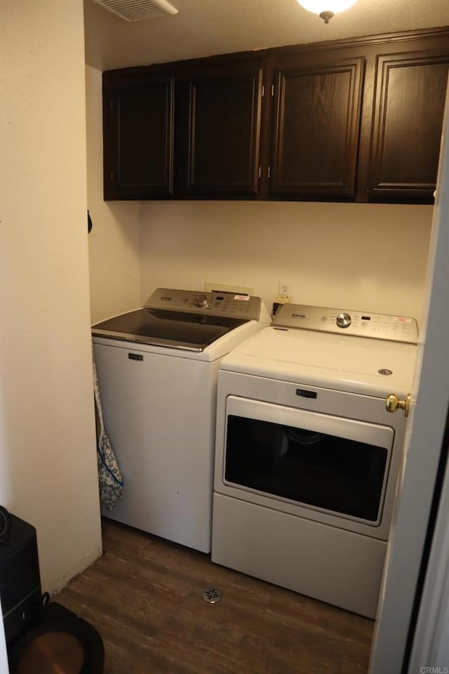 laundry area with cabinets, dark hardwood / wood-style flooring, and washer and dryer