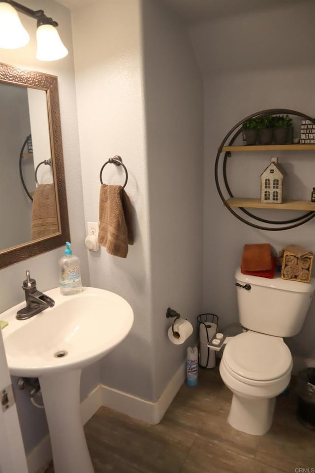 bathroom with hardwood / wood-style floors and toilet