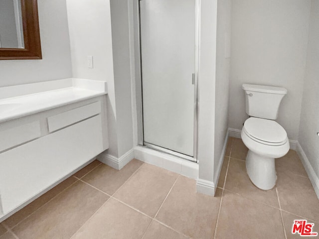 bathroom with vanity, tile patterned flooring, a shower with door, and toilet