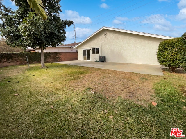 rear view of house featuring a yard and a patio