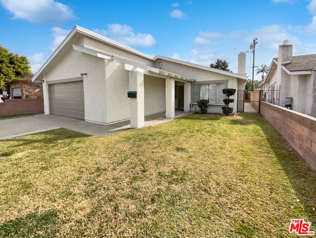 back of property featuring a garage and a yard