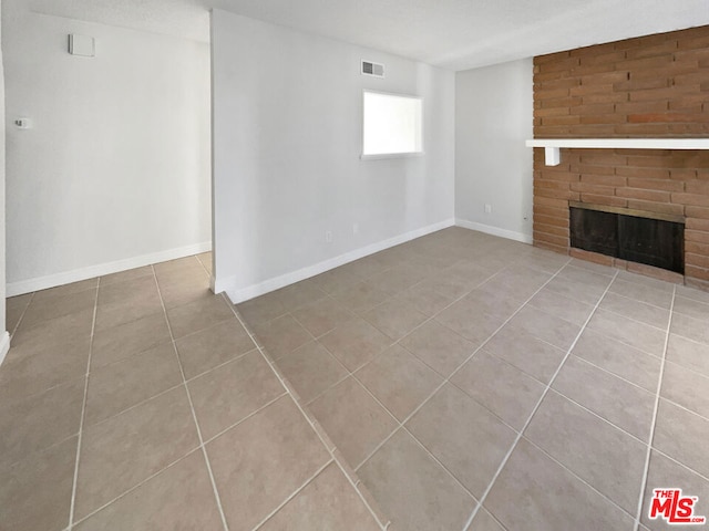 unfurnished living room with light tile patterned floors and a fireplace