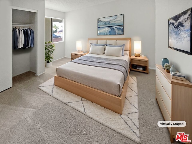 bedroom with light colored carpet, a closet, and a textured ceiling