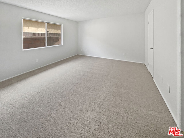 unfurnished room with a textured ceiling and carpet flooring