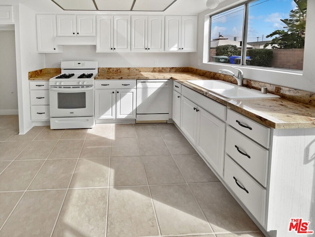 kitchen featuring white cabinetry, white appliances, sink, and light tile patterned floors