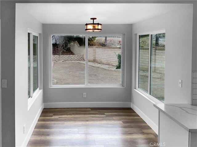 unfurnished dining area with dark wood-type flooring