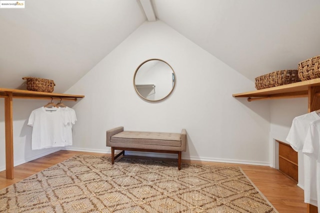 spacious closet with lofted ceiling with beams and hardwood / wood-style floors