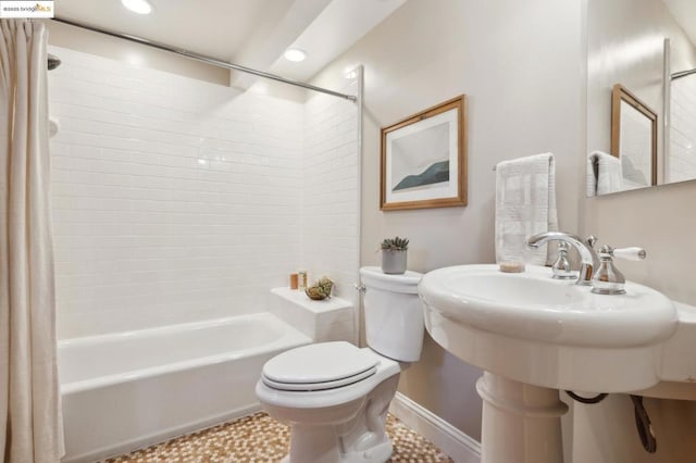 bathroom with tiled shower / bath combo and toilet