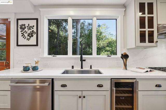 bar with wine cooler, sink, stainless steel dishwasher, and white cabinets