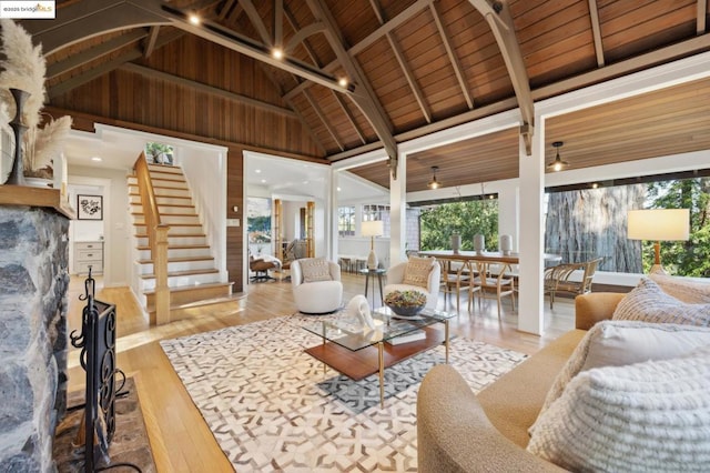 living room featuring wood ceiling, light hardwood / wood-style flooring, high vaulted ceiling, and beamed ceiling