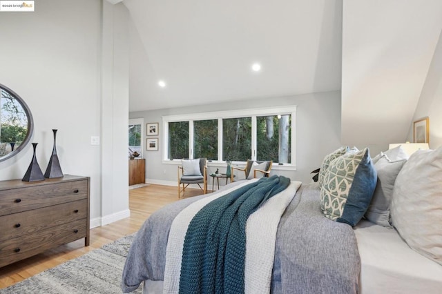 bedroom with high vaulted ceiling and light wood-type flooring