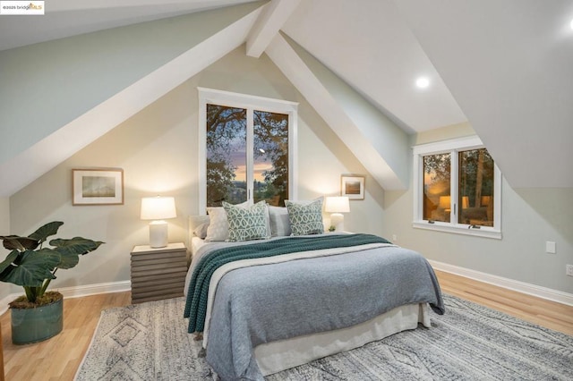 bedroom featuring hardwood / wood-style floors and vaulted ceiling with beams