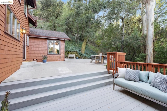 wooden terrace with an outdoor living space