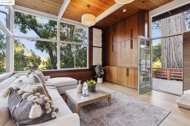 living room with wooden walls, a wealth of natural light, and wooden ceiling