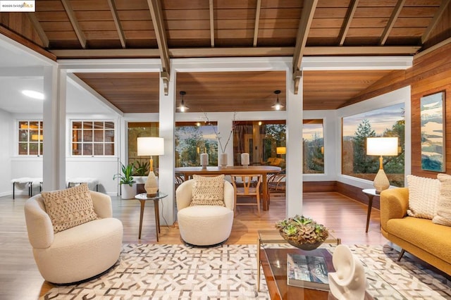 sunroom with vaulted ceiling with beams, a wealth of natural light, and wooden ceiling