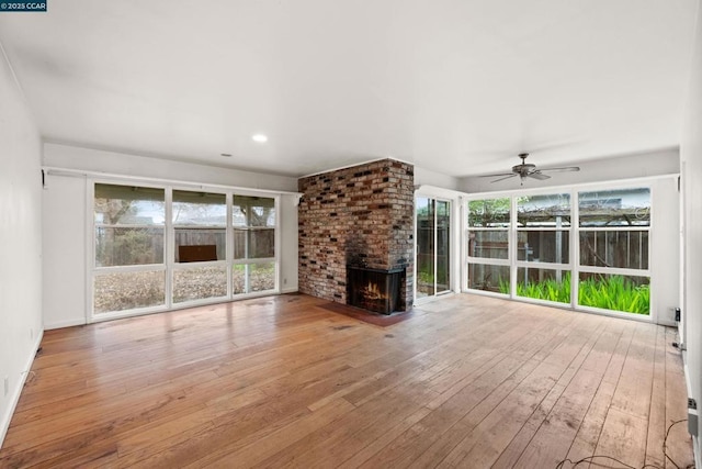 unfurnished living room featuring ceiling fan, a fireplace, and light hardwood / wood-style floors