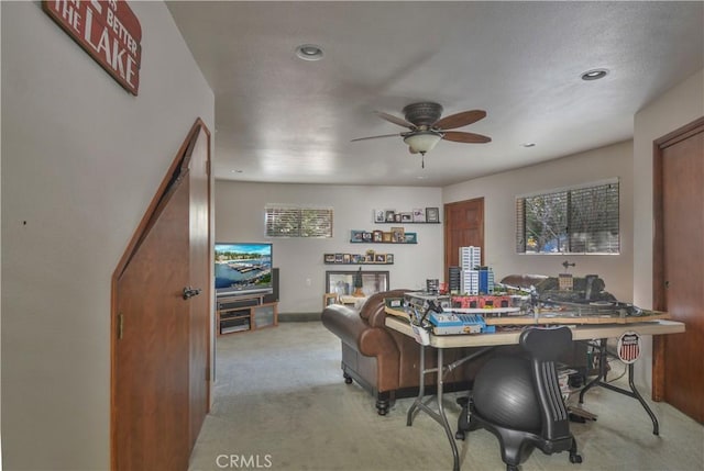 office space featuring ceiling fan and light carpet