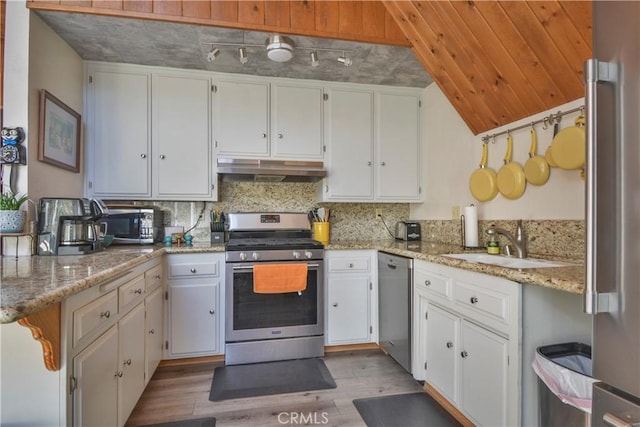 kitchen with white cabinetry, appliances with stainless steel finishes, and light stone counters