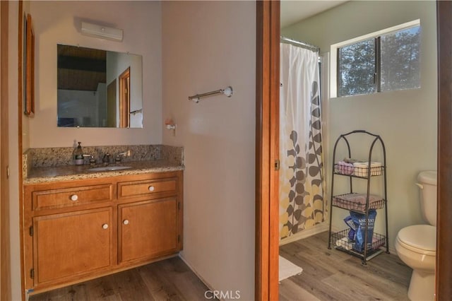 bathroom featuring a shower with curtain, vanity, hardwood / wood-style floors, and toilet