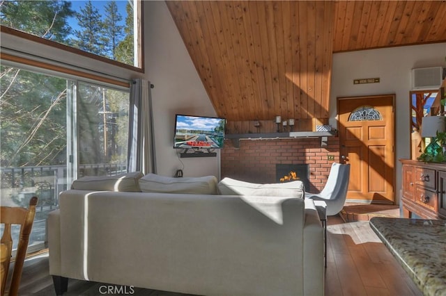 living room with a high ceiling, wood-type flooring, a brick fireplace, and wood ceiling