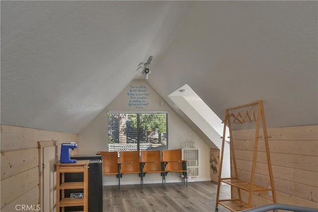 additional living space featuring vaulted ceiling and hardwood / wood-style floors