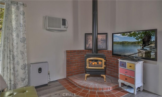 interior details featuring a wall mounted air conditioner, hardwood / wood-style floors, and a wood stove