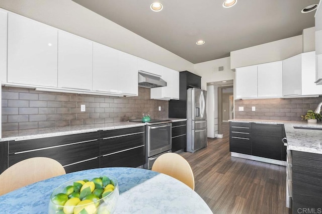 kitchen featuring sink, appliances with stainless steel finishes, dark hardwood / wood-style floors, extractor fan, and white cabinets