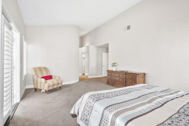 carpeted bedroom with high vaulted ceiling