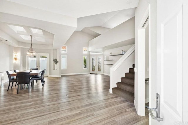 foyer featuring a notable chandelier, light wood-type flooring, and french doors