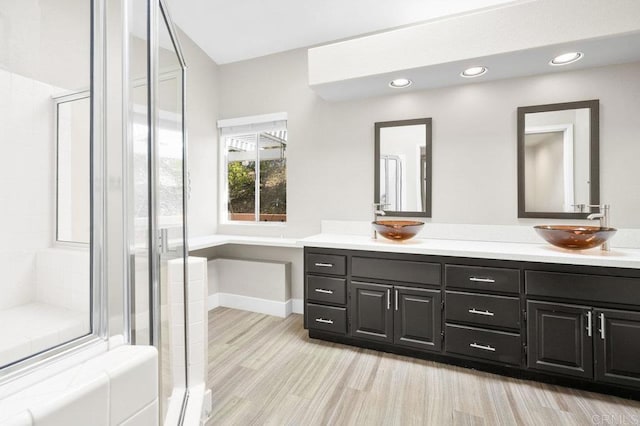 bathroom with vanity, an enclosed shower, and wood-type flooring