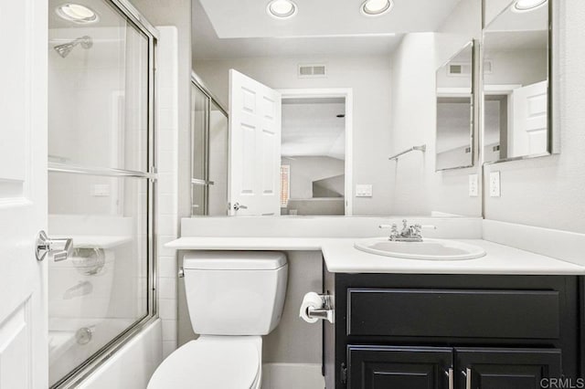 full bathroom with enclosed tub / shower combo, vanity, and toilet