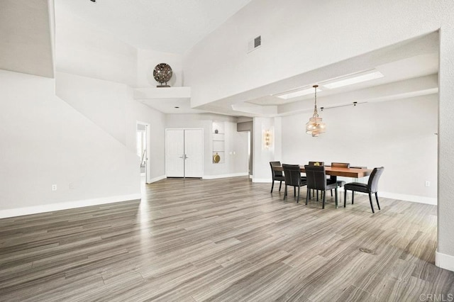 dining space featuring a high ceiling and hardwood / wood-style floors