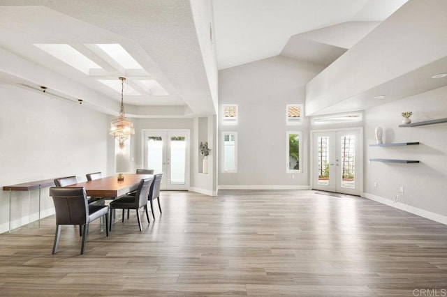 dining area featuring wood-type flooring, french doors, and vaulted ceiling