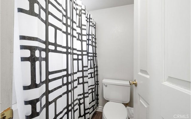 bathroom with a shower with curtain and toilet