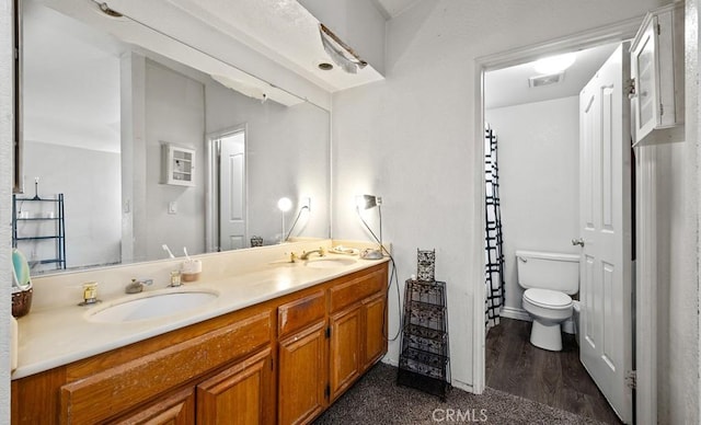 bathroom featuring vanity, hardwood / wood-style floors, and toilet