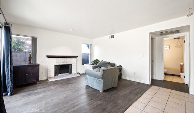 living room featuring a brick fireplace and hardwood / wood-style floors