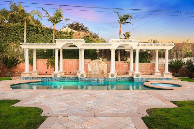 pool at dusk with an in ground hot tub, a pergola, and a patio