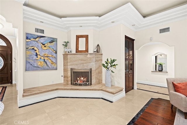 interior space featuring a tray ceiling, a fireplace, and ornamental molding