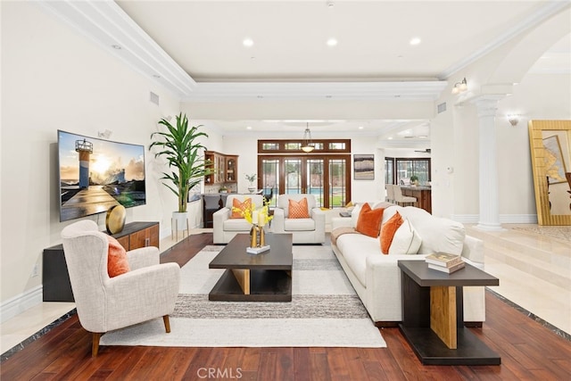 living room featuring dark hardwood / wood-style flooring, ornamental molding, and ornate columns