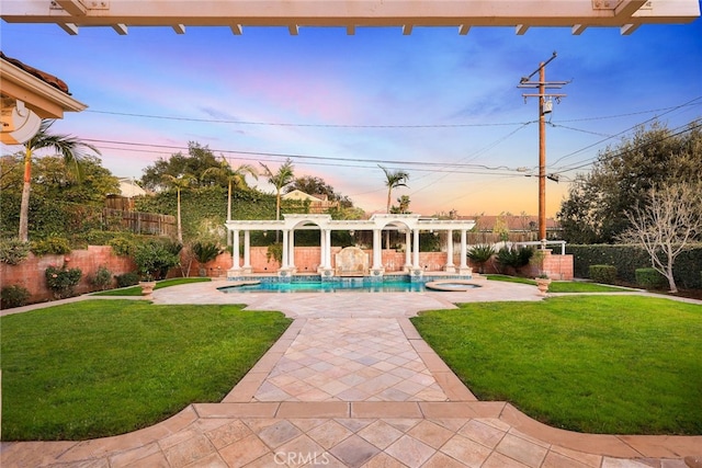 pool at dusk featuring a pergola, a lawn, a patio area, and an in ground hot tub