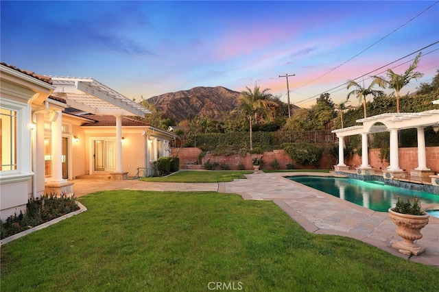 yard at dusk with a fenced in pool, a patio, a mountain view, and a pergola