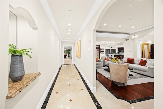 hall with crown molding and decorative columns