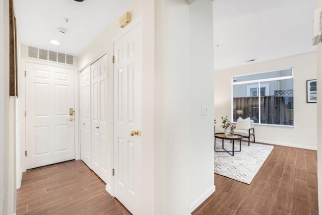 corridor with hardwood / wood-style flooring