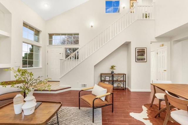 living room with wood-type flooring and high vaulted ceiling