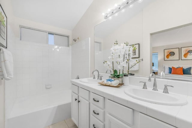 bathroom featuring tiled shower / bath, tile patterned floors, and vanity