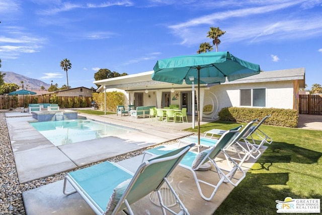 view of swimming pool featuring a mountain view, a yard, a patio area, and an in ground hot tub