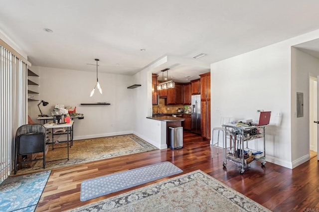 interior space with dark hardwood / wood-style flooring, stainless steel fridge with ice dispenser, decorative light fixtures, and electric panel