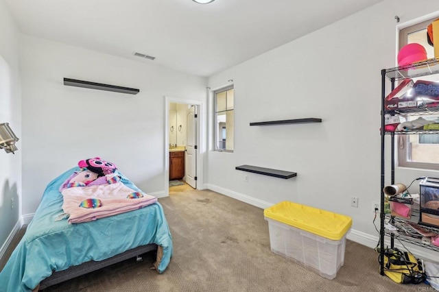 bedroom with light colored carpet and ensuite bath