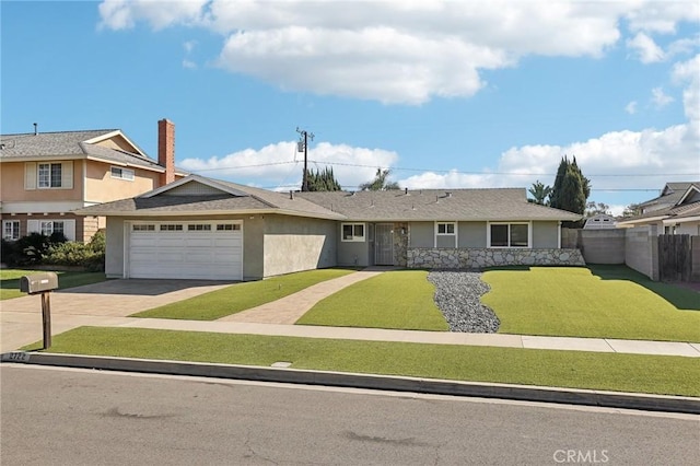 view of front of house featuring a garage, driveway, stucco siding, fence, and a front yard