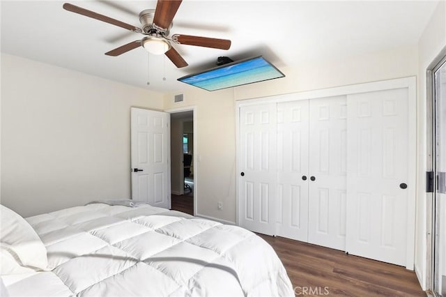 bedroom with ceiling fan, a closet, dark wood finished floors, and visible vents